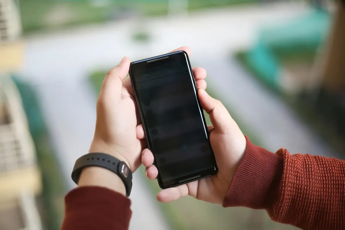 Android App Development Hands holding and testing a smartphone for Android app development